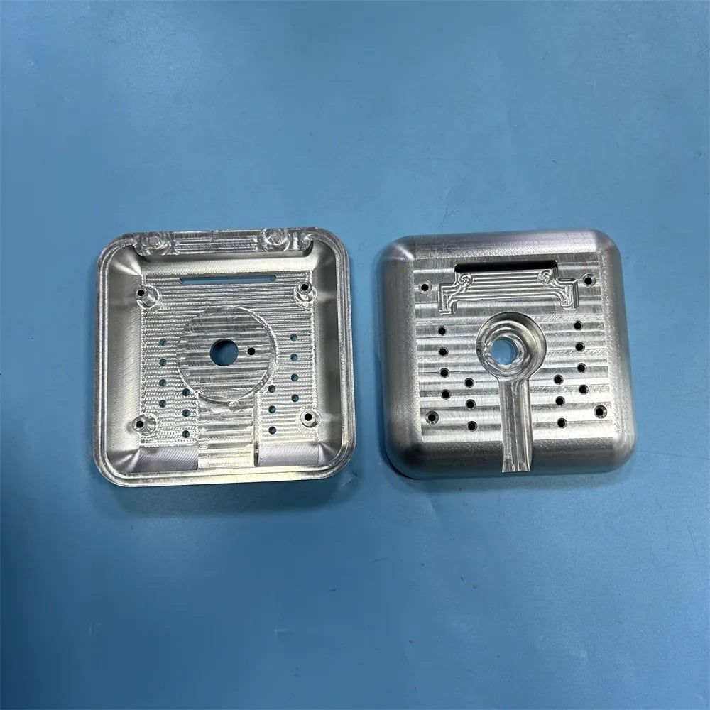 Two machined aluminum enclosure halves with internal pocketing and bored holes