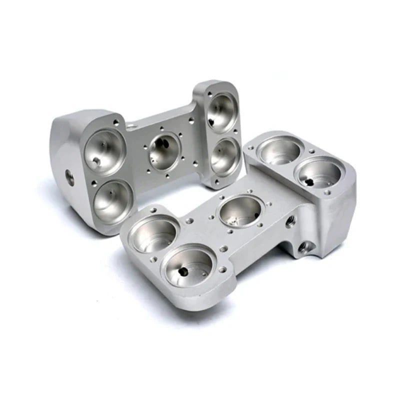 Two polished aluminum housings with multiple spherical bores and a central bolt pattern