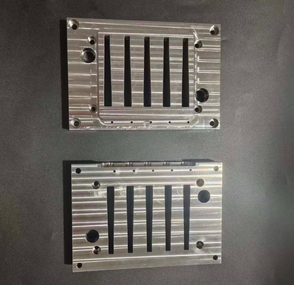Two aluminum plates with parallel slots and bored holes