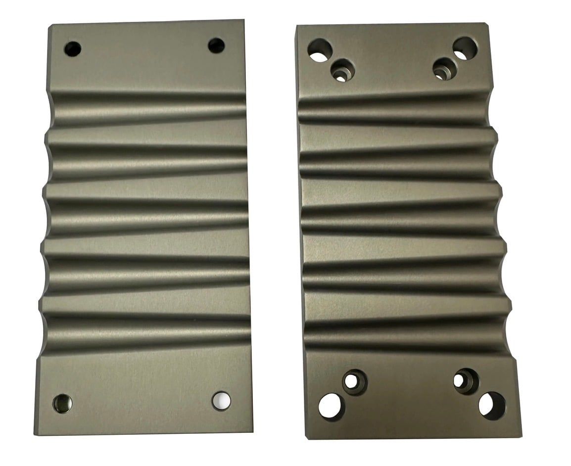 Two grey anodized aluminum panels with fluted faces and mounting holes