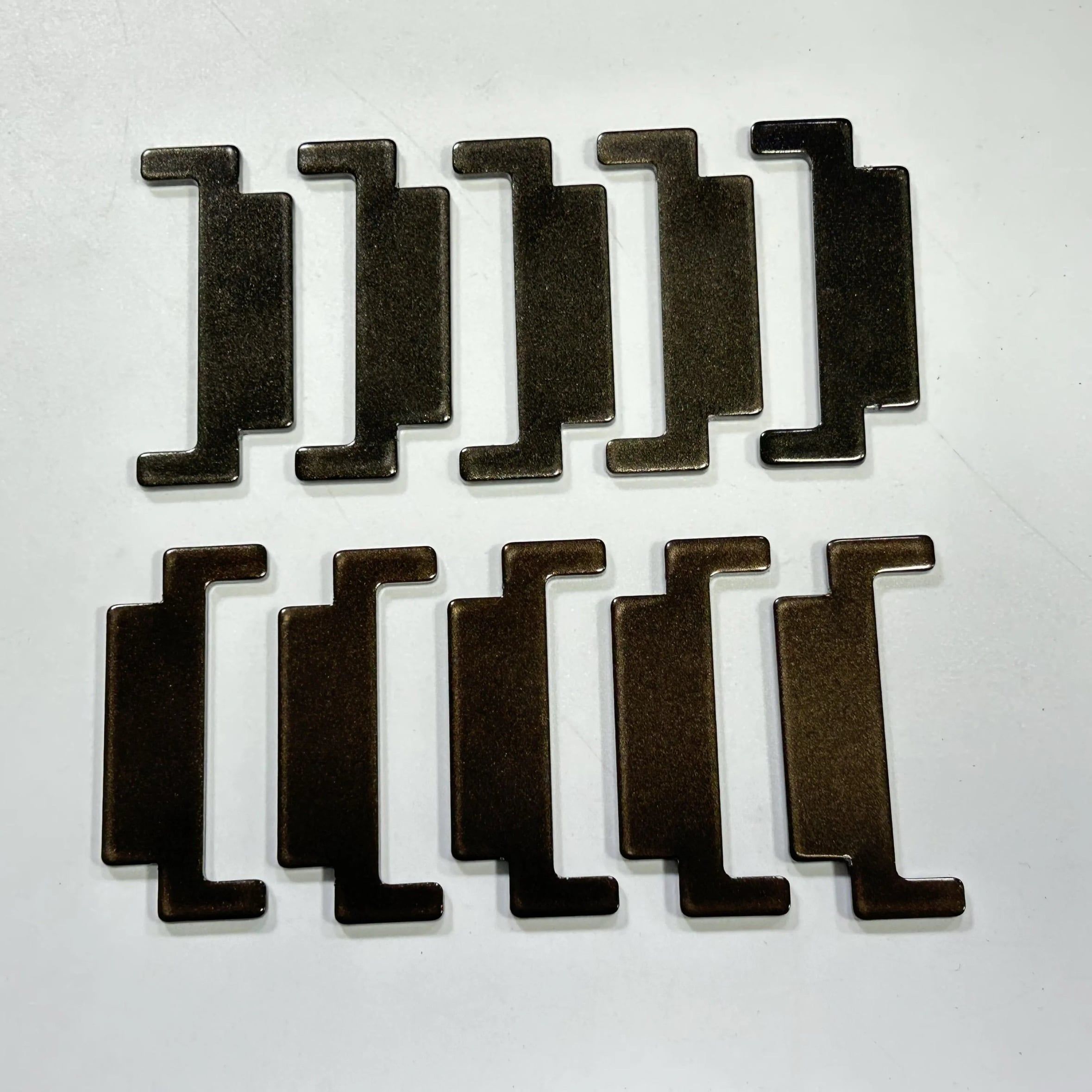Ten dark anodized Z-shaped mounting clips arranged in two rows